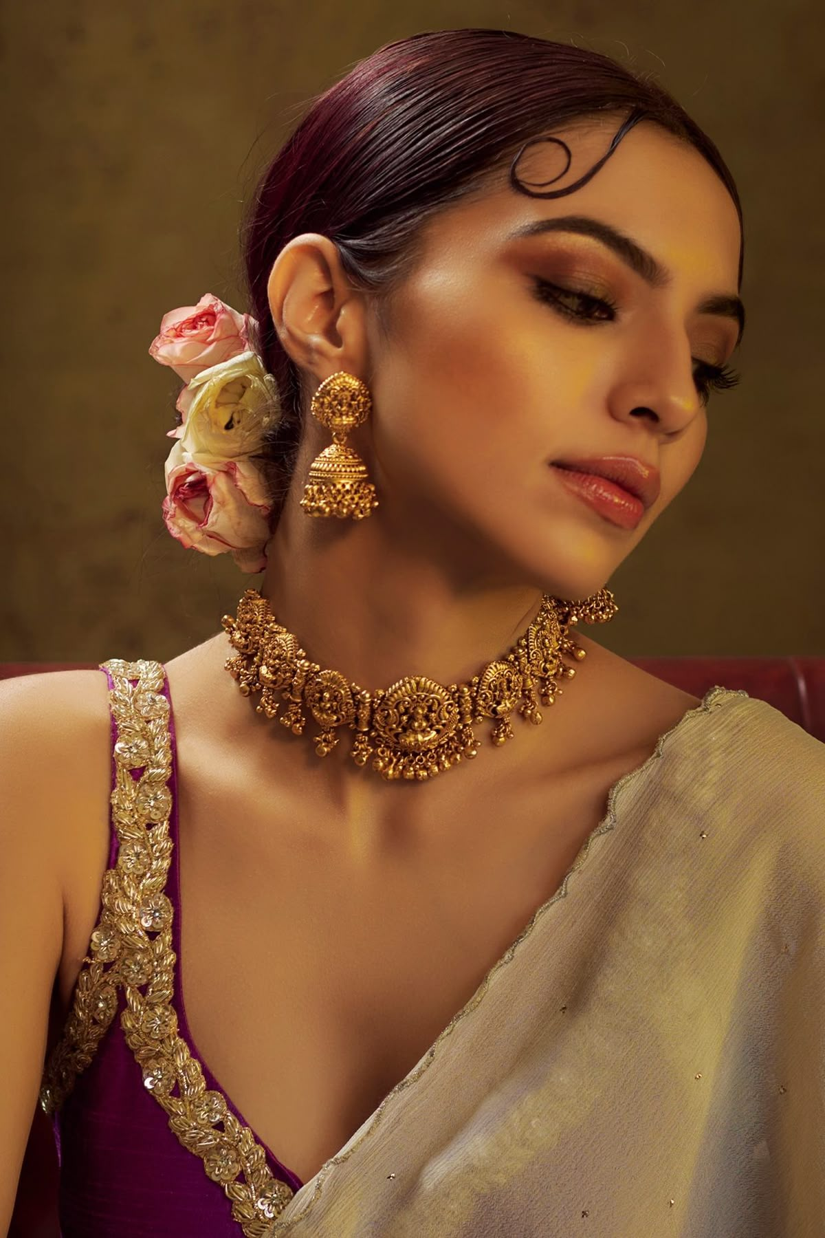 Woman wearing traditional Indian gold jewellery — necklace and earrings